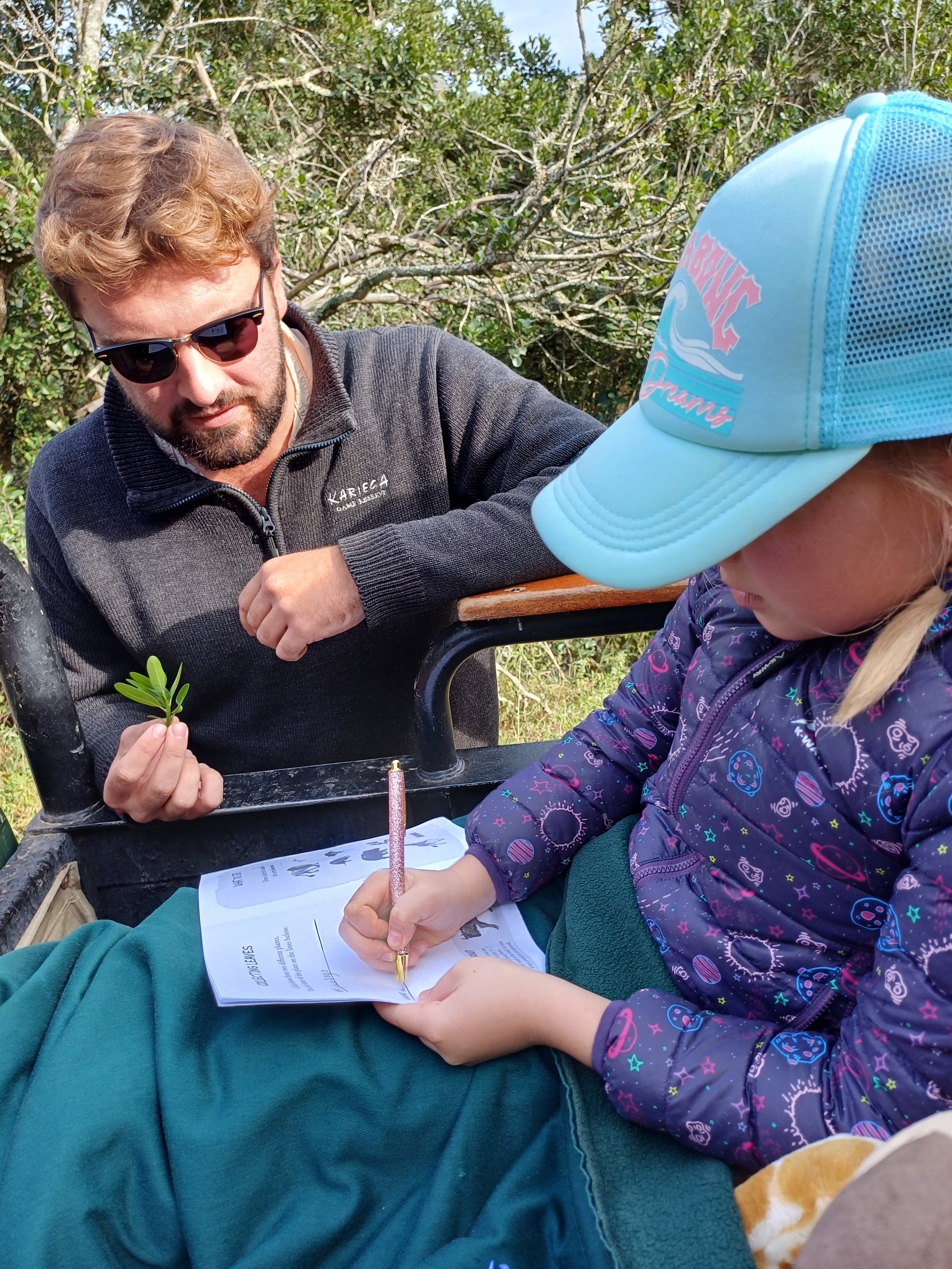 Kids on Safari - Kariega guest filling out info in the children's activity booklet with her guide Lloyd - Img taken by former guest Laurina