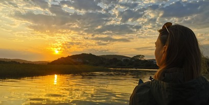 Volunteer watching the sunset on the river